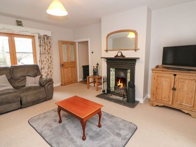 A living room with a sofa coffee table fireplace and television at Coffey's in Ballymacarbry County Waterford
