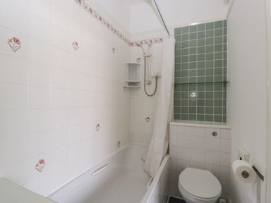 A bathroom with a bathtub shower and toilet at Alcombe House in Minehead