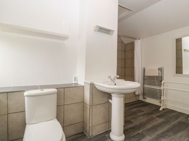 A bathroom with a toilet sink shower with curtain and towel rack at Alcombe House in Minehead