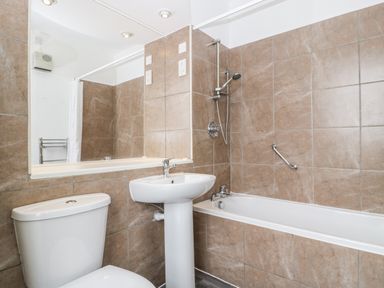 A bathroom with a toilet sink and bathtub with shower at Alcombe House Minehead