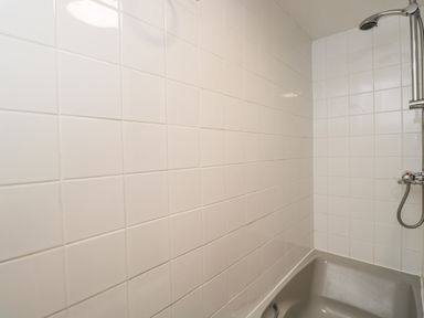 A bathroom with a bathtub and a showerhead above the tub at Paddock Cottage Nr Malmesbury