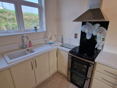 A kitchen corner with a double sink stove and decorative sailboat at Beach House in Duncannon County Wexford
