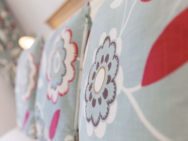 Close up of floral patterned cushions on a bed at Surf and Sand in Carbis Bay