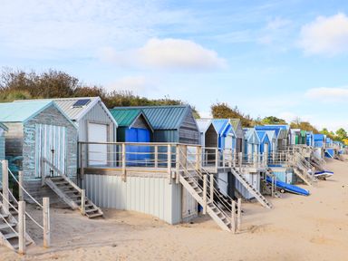 A row of beach huts with stairs leading to sandy beach at 240 Cae Du in Abersoch