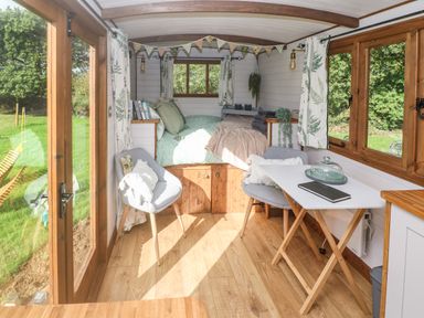A small room with a bed at the end two chairs and a table near large wooden windows at Fern in Broad Langdon near Wainhouse Corner