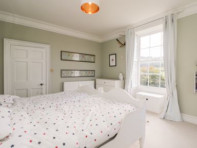 A bedroom with two single beds near a window and white furniture at Rockstowes House in Uley near Dursley