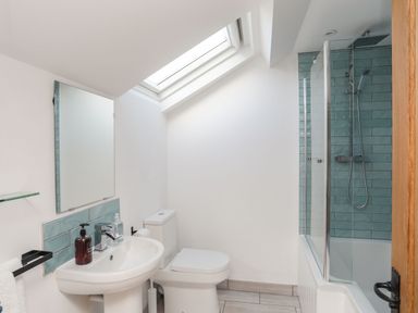 A bathroom with a sink toilet bathtub and skylight at Bodwena in Moelfre