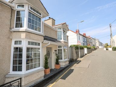 A street view with terraced houses and bay windows at Bodwena in Moelfre