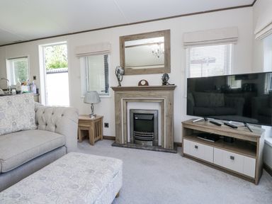 A living room with a sofa and fireplace at Lilac Lodge in Carnforth