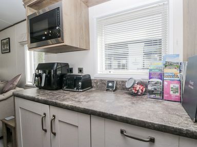 A kitchen countertop with appliances and brochures at Lilac Lodge in Carnforth