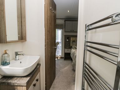 A bathroom with a sink and mirror at Lilac Lodge in Carnforth