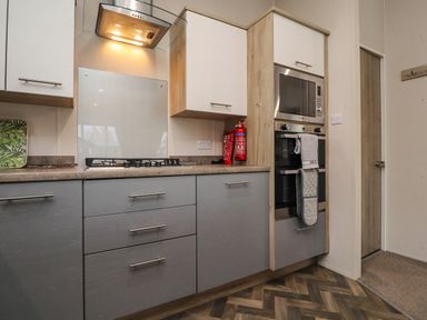 A kitchen with gas stove oven microwave cabinets and a fire extinguisher at Fountain View in Warton near Carnforth