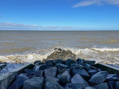 A rocky shoreline with steps leading down to the sea at Beck View in Sheringham