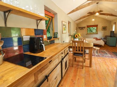 A kitchen with wooden furniture and a coffee maker at Brambly Cabin in Crediton