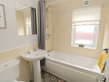 A bathroom with a sink toilet and bathtub with shower at Mildred's Lodge in Felton