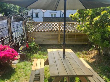 A garden with a table and umbrella at 6 Calgarth View Windermere