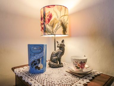 A table with a box of Lindt chocolates a decorative fox lamp and a floral teacup and saucer at 12 Castlegate in Pickering