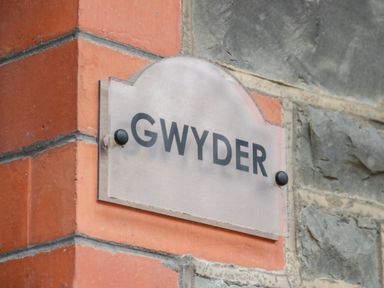 A sign with the word Gwyder mounted on a brick and stone wall at Gwyder in Penmaenmawr