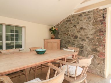 A dining room with a large table and chairs at Wayside near Kingsbridge