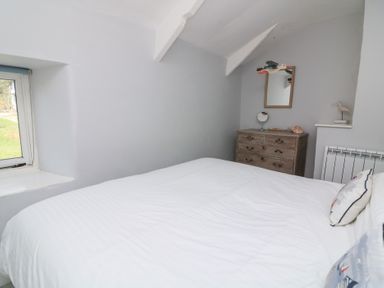 A bedroom with a bed and dresser at Wayside near Kingsbridge