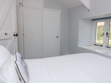 A bedroom with bed and wardrobe at Wayside near Kingsbridge