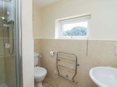 A bathroom featuring a shower, toilet, and sink at Wayside near Kingsbridge
