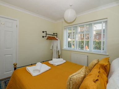 A bedroom with a bed covered in yellow bedding and folded white towels on top at See The Sea in Hunstanton