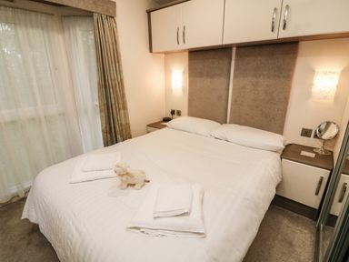 A bedroom with a double bed towels and a small stuffed animal on the bed at 3 Yealands in Carnforth