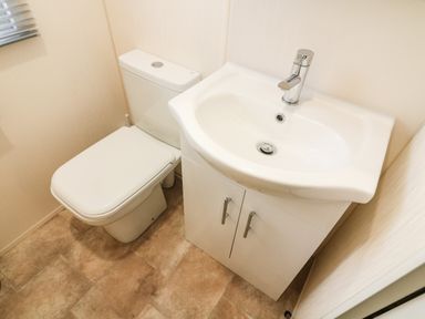 A bathroom with a toilet and a white sink cabinet at 3 Yealands in Carnforth