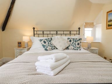 A bedroom with a bed with pillows and folded towels on the bed at 5 Packhorse in Purton