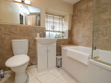 A bathroom with a toilet sink cabinet shower bath and window blinds at 5 Packhorse in Purton