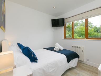 A bedroom with a bed and window at Branock, Tor Down Quarry in St Breward
