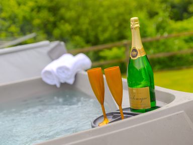 A hot tub with champagne and glasses at Branock, Tor Down Quarry, St Breward