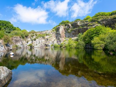 A body of water surrounded by rock cliffs and greenery at Branock, Tor Down Quarry St Breward