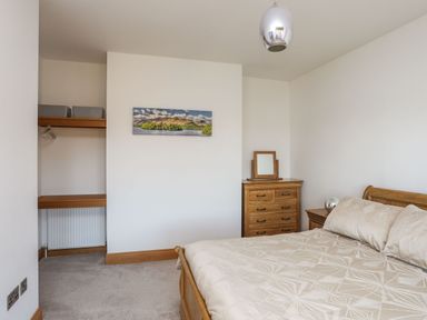 A bedroom with a bed dresser and open closet at Bryn Mel Manor Straits View Menai Bridge
