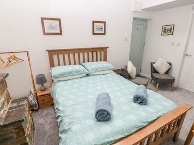 A bedroom with a double bed and rolled towels on it at Ty Rhydd in Newport Pembrokeshire