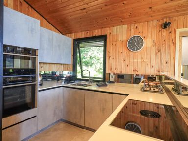 A kitchen with a countertop stove oven sink toaster and wall clock at Greengarth in Yanwath near Penrith