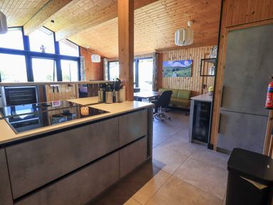 A kitchen and dining area with wood paneling and large windows at Greengarth in Yanwath near Penrith