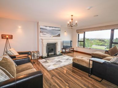 A living room with sofas a fireplace a television and large windows with a view at Upper Killult in Killult near Gortahork County Donegal
