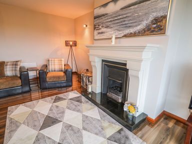 A living room with two armchairs a fireplace and a geometric patterned rug at Upper Killult in Killult near Gortahork County Donegal