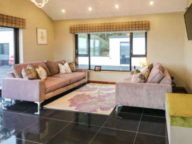 A living room with two sofas and a patterned rug at Upper Killult in Killult near Gortahork County Donegal