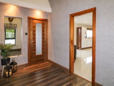 A hallway with wooden floor and two doorways one leading to kitchen and the other closed wooden door at Upper Killult in Killult near Gortahork County Donegal