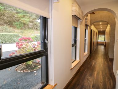 A long hallway with several windows on one side and wooden flooring at Upper Killult in Killult near Gortahork County Donegal