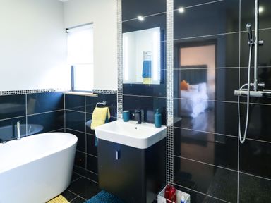 A bathroom with a bathtub sink mirror shower and towel racks at Upper Killult in Killult near Gortahork County Donegal