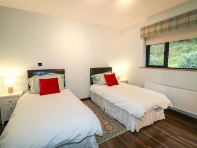 A bedroom with two single beds side by side with red cushions and white bed covers at Upper Killult in Killult near Gortahork County Donegal