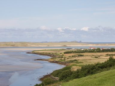 A coastal landscape with a shoreline green fields and houses at Upper Killult in Killult near Gortahork County Donegal