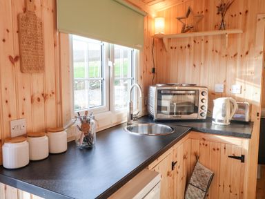 A kitchen countertop with a sink toaster oven electric kettle jars and utensils at Shepherds Retreat Glenlark in Gortin near Greencastle