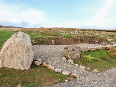 An outdoor area with large rocks and gravel pathway in a grassy field at Shepherds Retreat Glenlark in Gortin near Greencastle