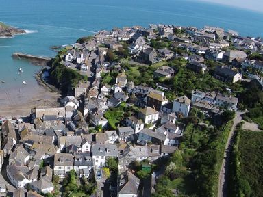 An aerial view of a coastal village with houses and a small harbor at Honey Cottage in Port Isaac