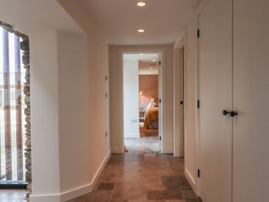 A hallway with tile flooring leading to a bedroom at 3 Caddaford Barns in Buckfastleigh
